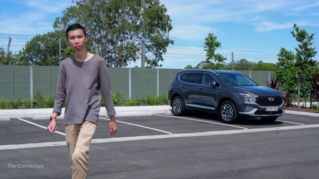Man looks towards sky while walking away from Hyundai Santa Fe Hybrid