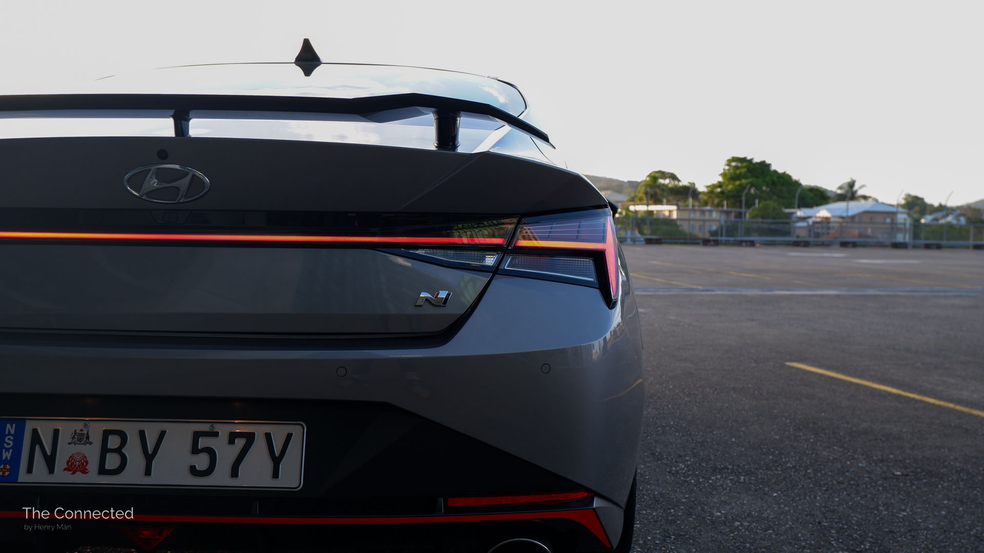 Hyundai i30 Sedan N LED tail-lights bar on in urban rooftop carpark