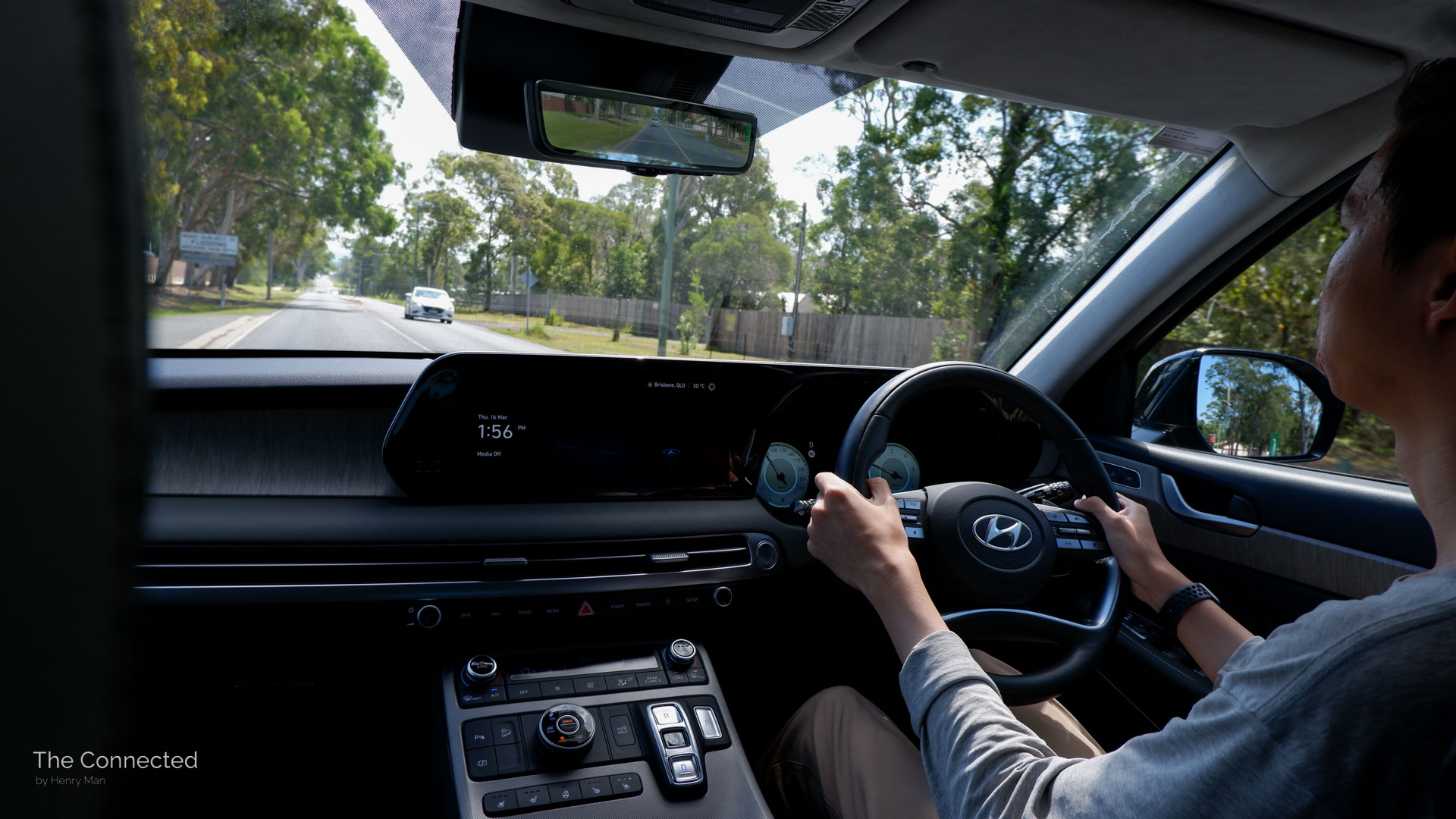 Man driving Hyundai Palisade Highlander interior view on back road