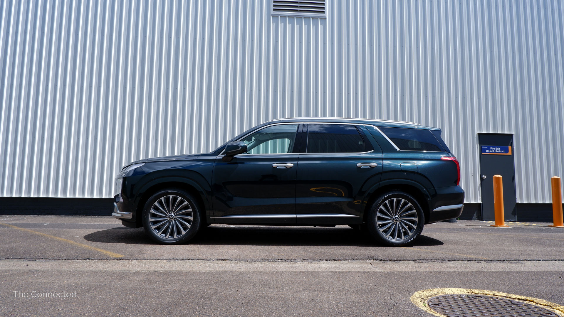 Hyundai Palisade Highlander side profile view in front of white container