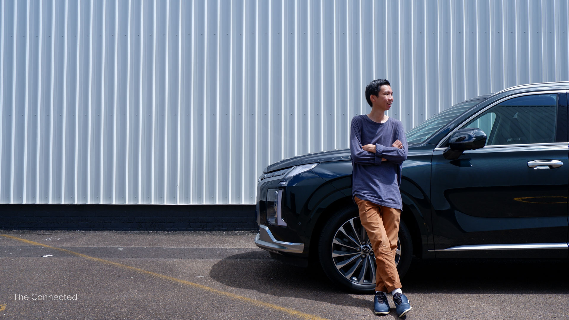 Man looking away leaning on Hyundai Palisade Highlander