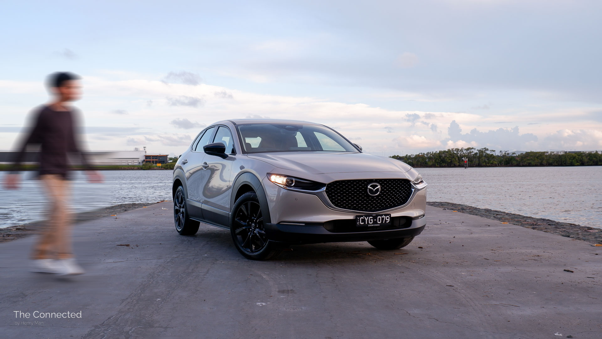 Man walks past 2025 Mazda CX-30 GT SP with river behind