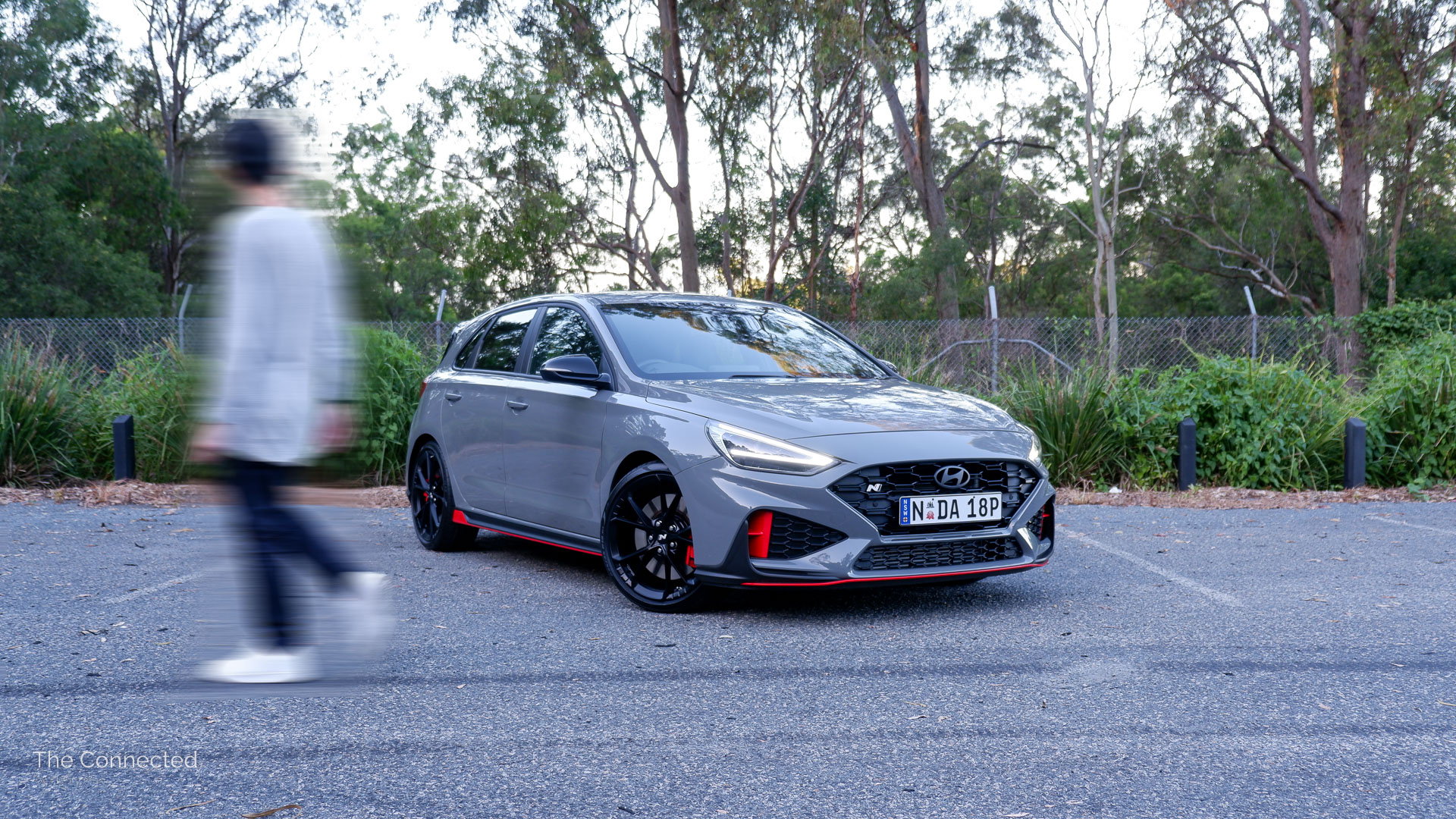 Man walks past 2025 Hyundai i30 N with forest behind