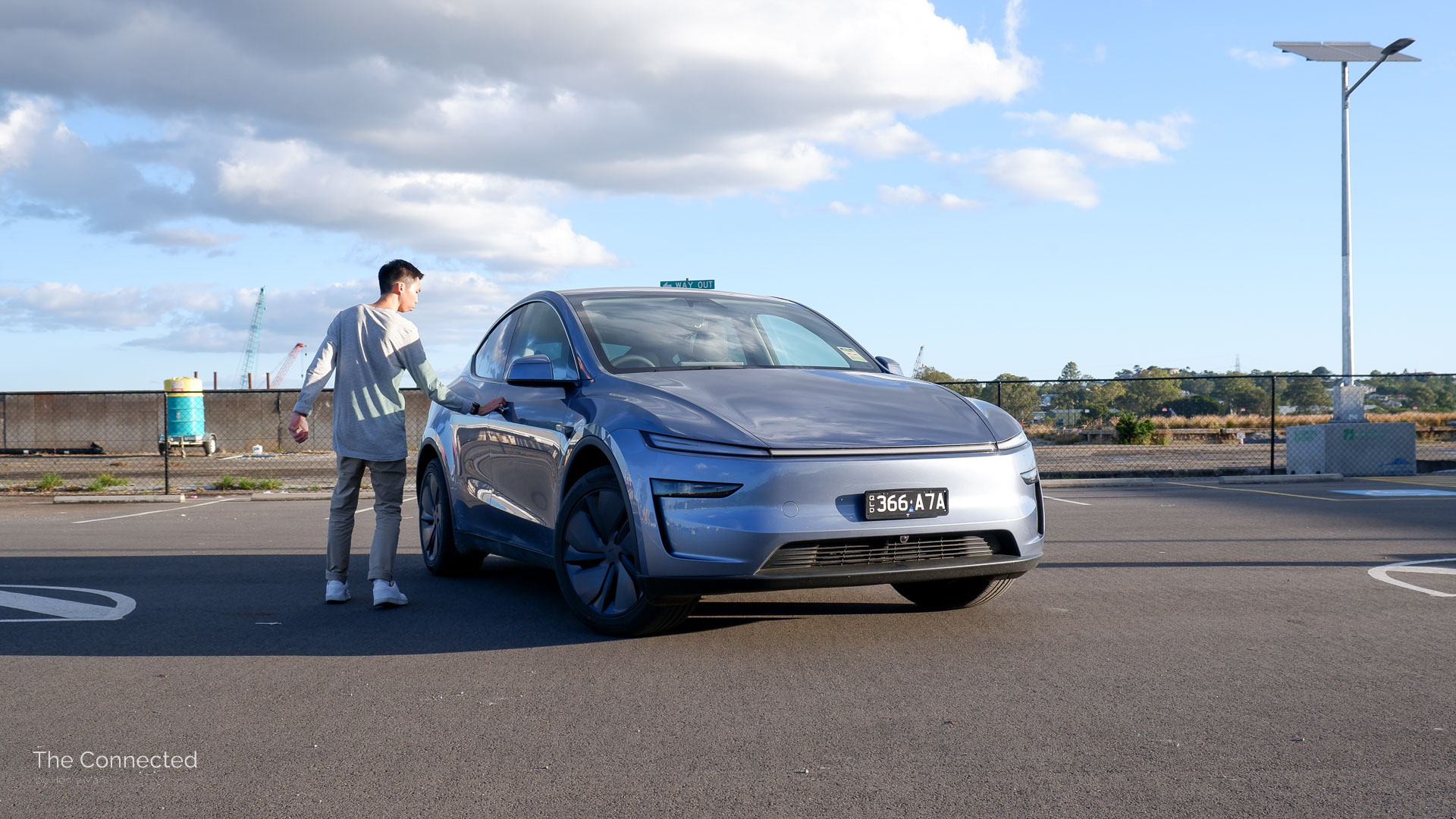 Man approaches 2025 Tesla Model Y RWD Glacier Blue