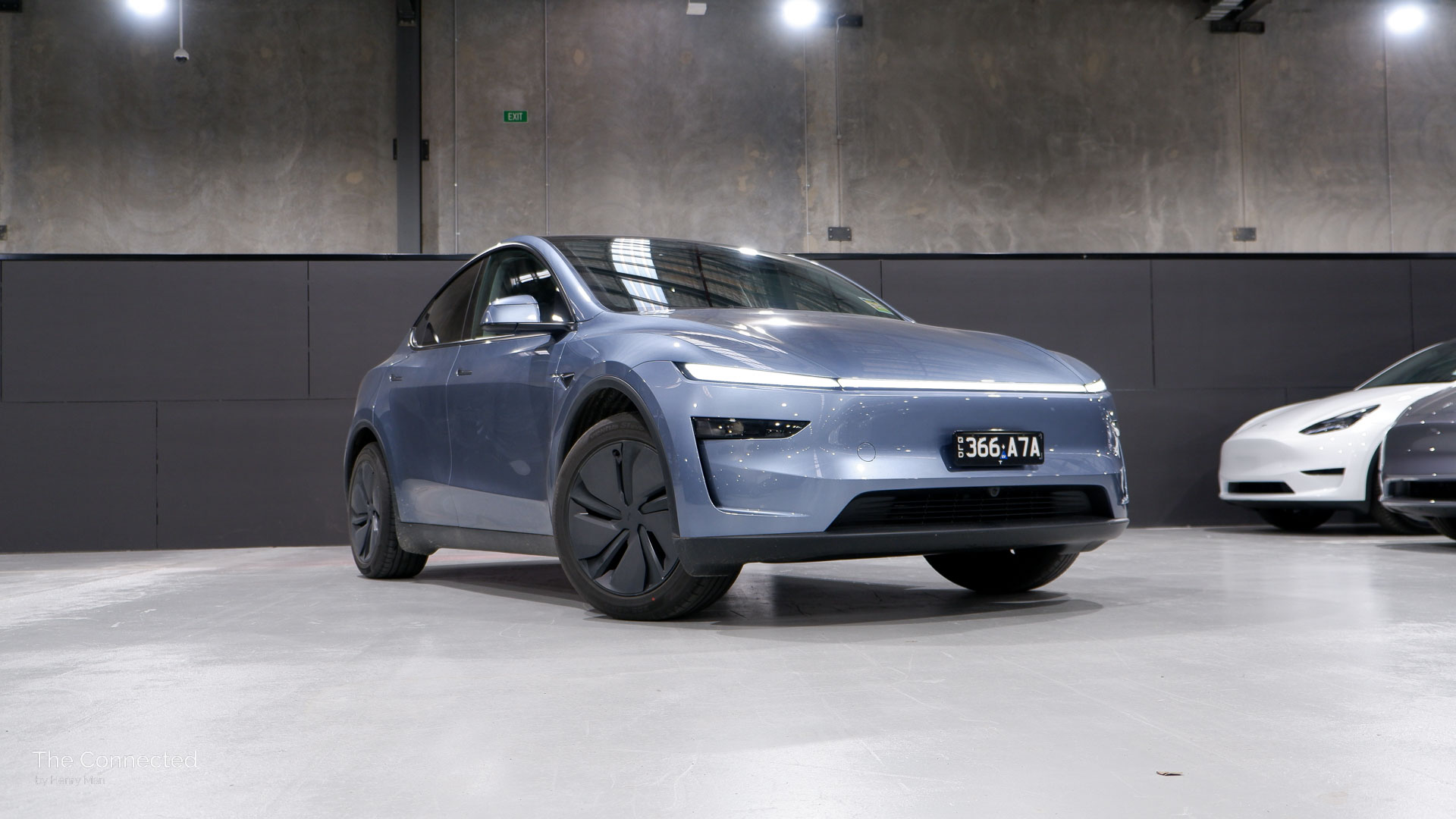 2025 Tesla Model Y RWD Glacier Blue front-quarter view with old Model Y behind