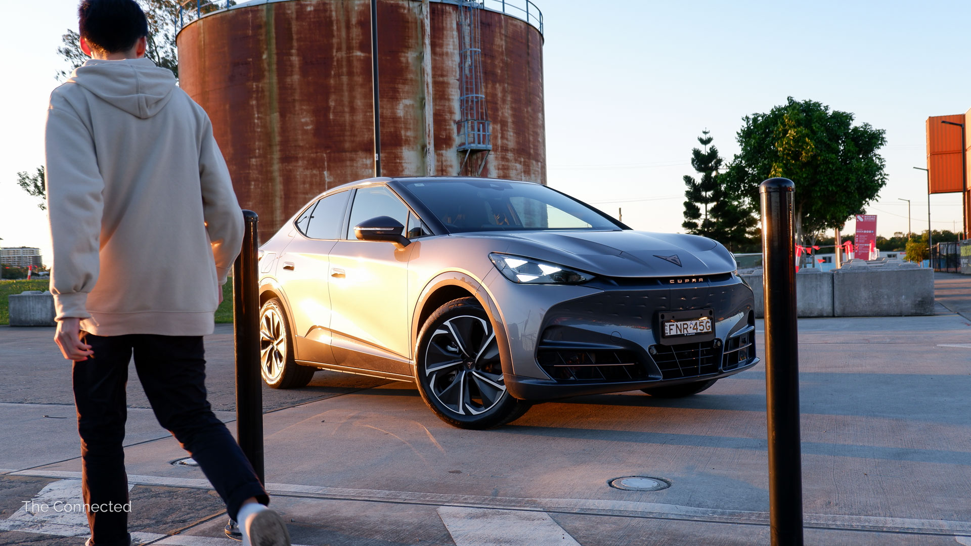 Man walks past 2026 Cupra Tavascan Endurance with Interior Package in the sunset