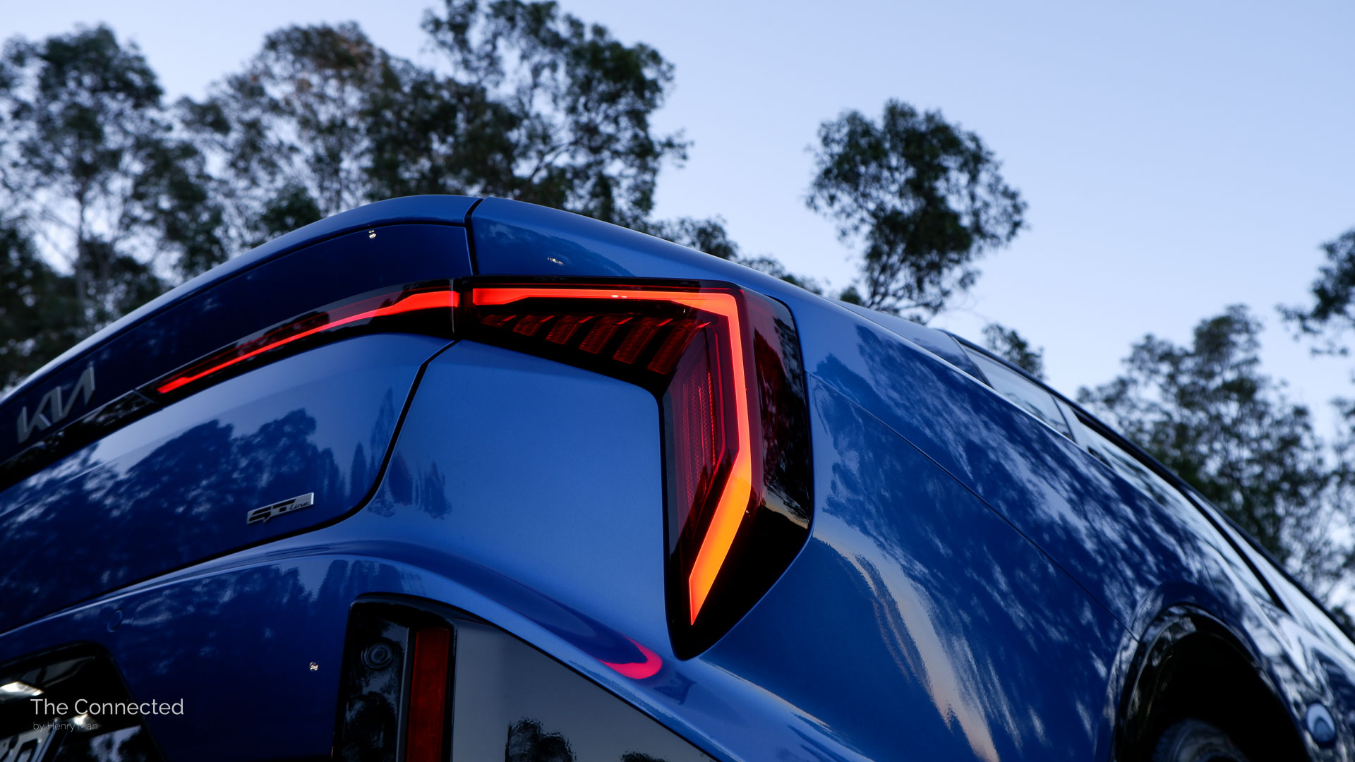 2026 Kia K4 Sedan GT-Line rear LED tail-light angled view with trees behind