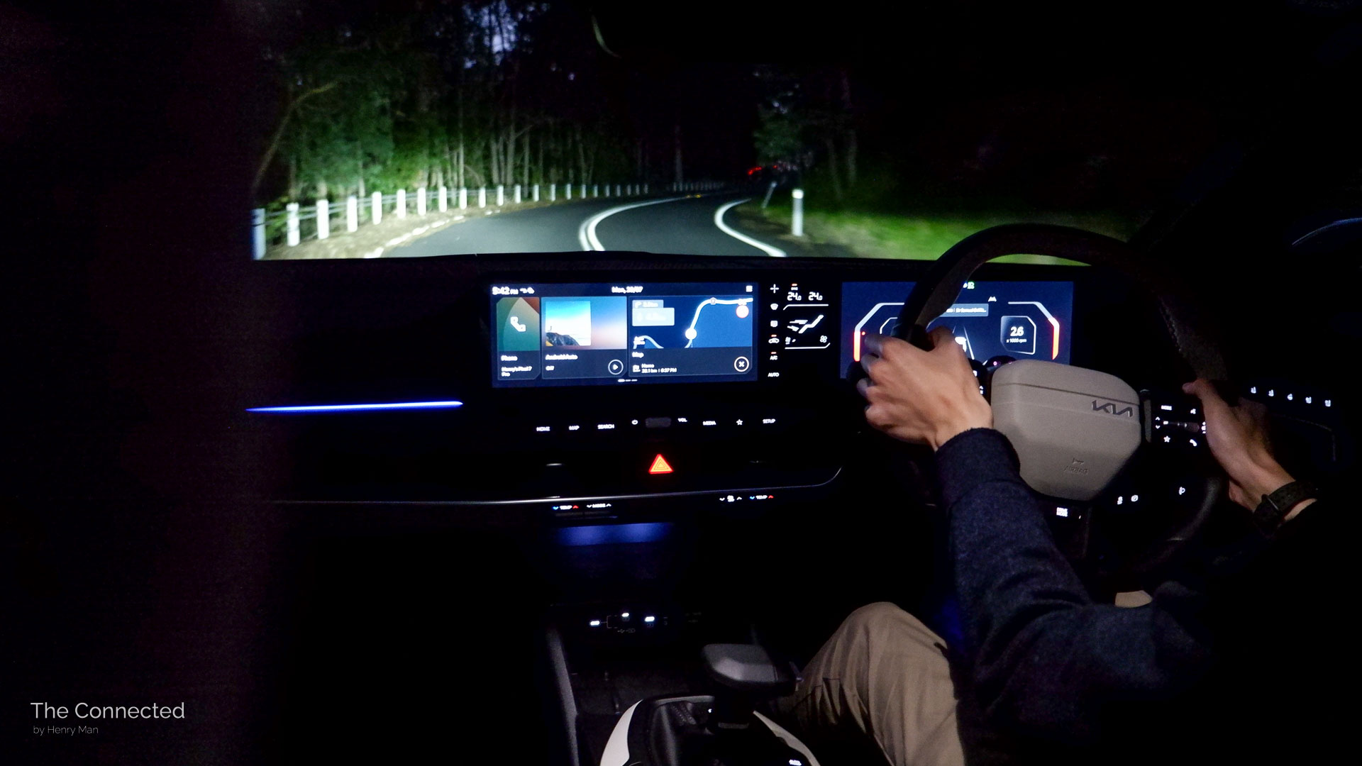 Man driving 2026 Kia K4 Sedan GT-Line through mountain at night