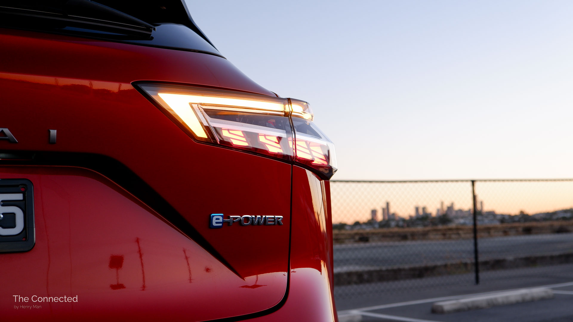 2026 Nissan Qashqai N-Design e-Power rear tail-light with sunset cityscape behind