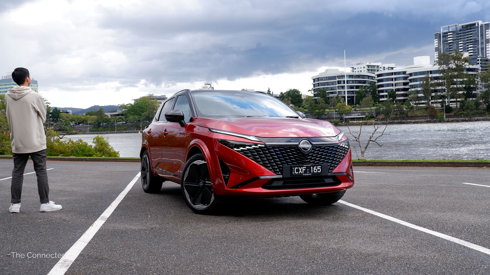 Man looks at 2026 Nissan Qashqai N-Design e-Power with the city behind