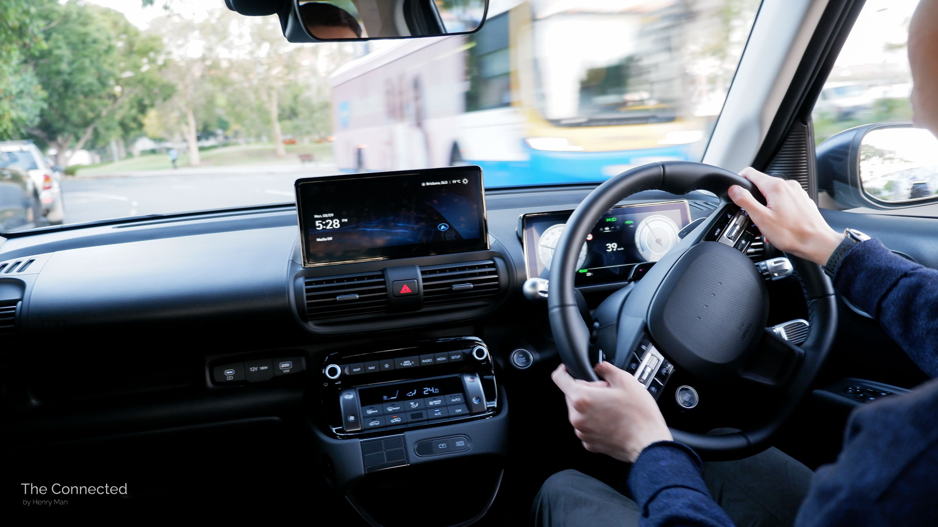 Man driving 2026 Hyundai Inster Standard Range with bus passing opposite