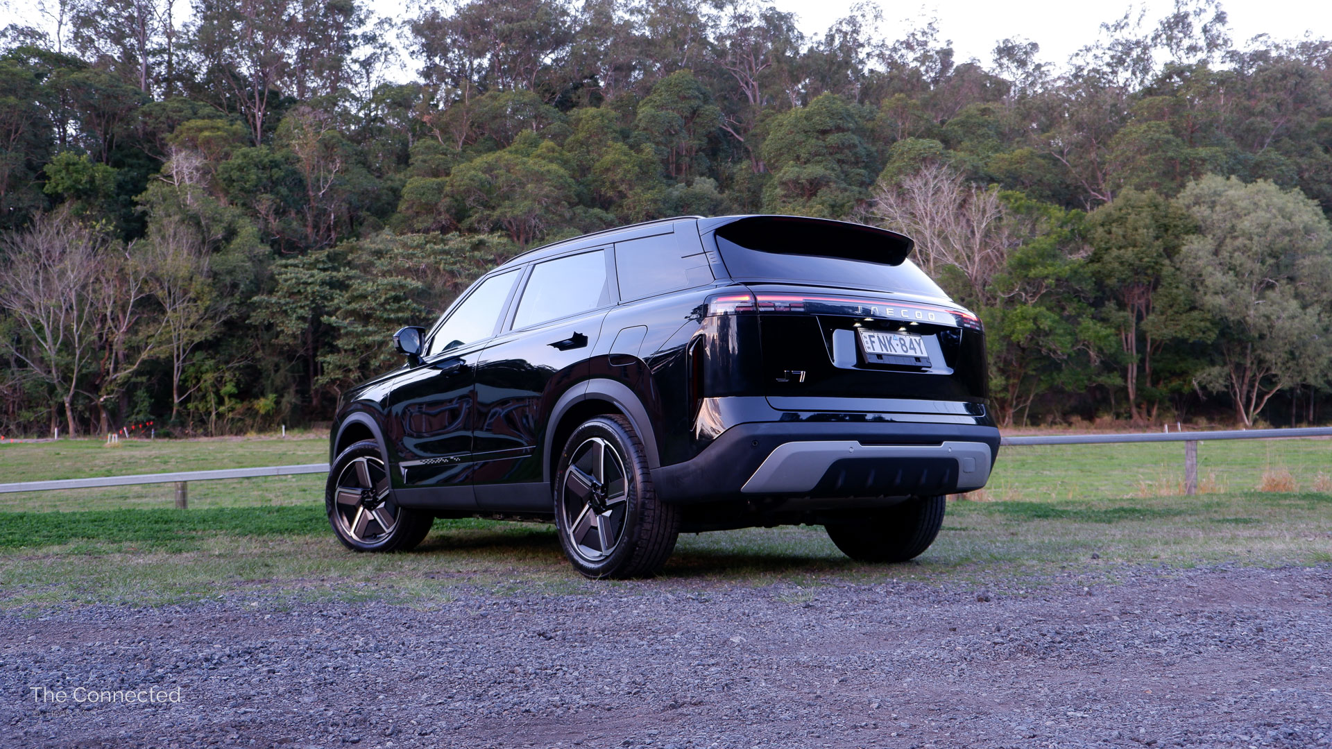 2026 Jaecoo J7 SHS Summit rear-quarter view with forest behind