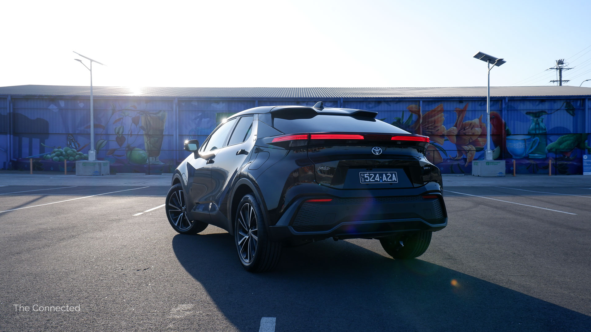 2026 Toyota C-HR Koba rear quarter view with an artwork shed behind