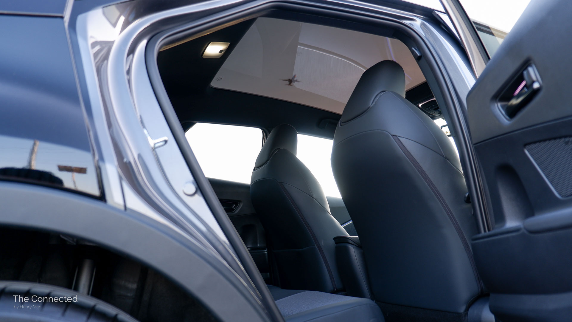 2026 Toyota C-HR Koba rear seats with a view of the panoramic glass roof showing a plane flying past