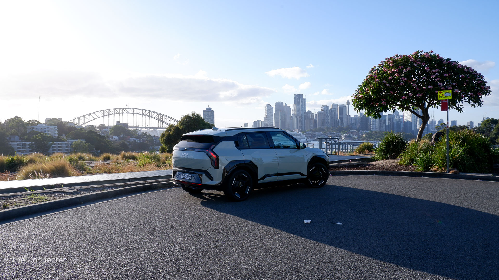 2025 Kia EV3 GT-Line rear-quarter view with Sydney Harbour Bridge and cityscape behind