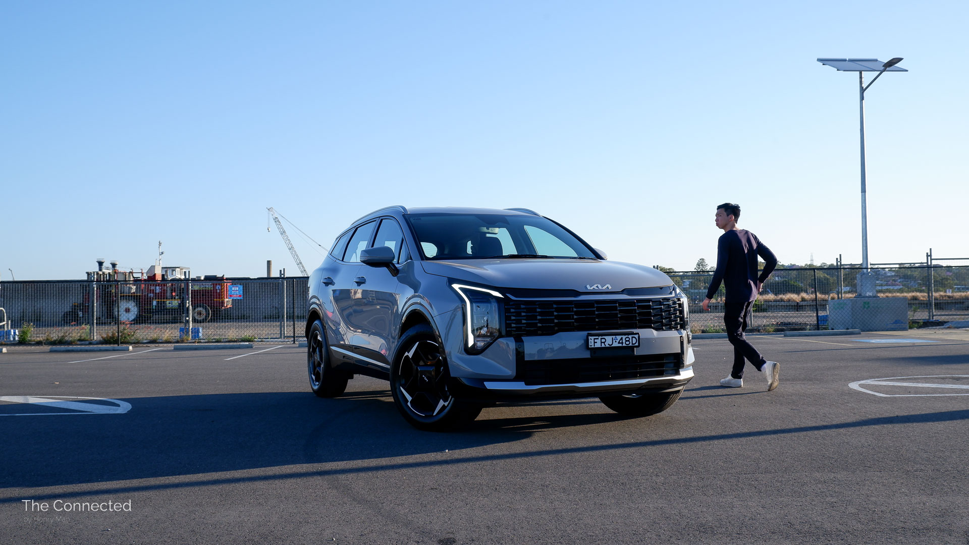 Man walks past the 2026 Kia Sportage SX Hybrid