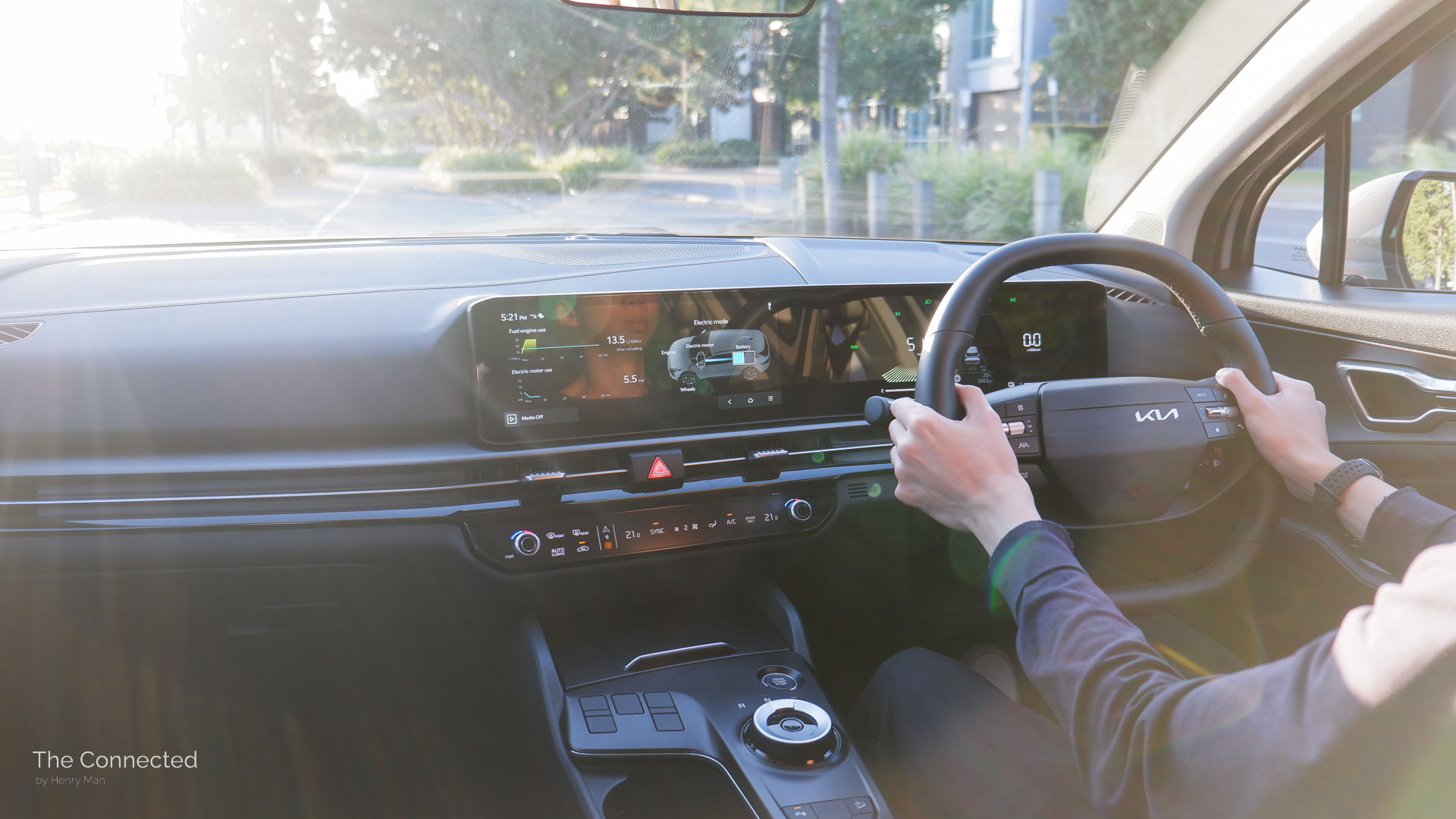 Man driving the 2026 Kia Sportage SX Hybrid in the sunset