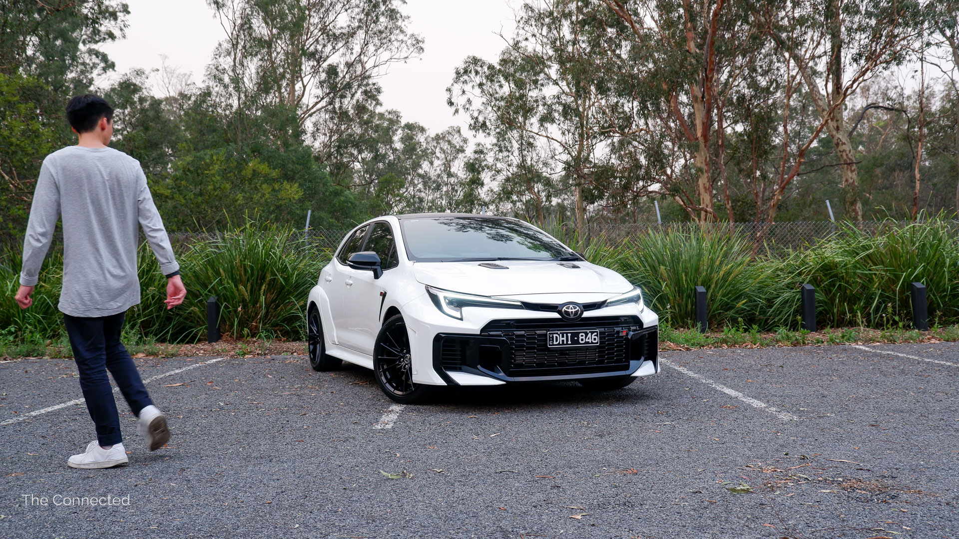 Man walks past the 2026 Toyota GR Corolla GTS with the forest behind