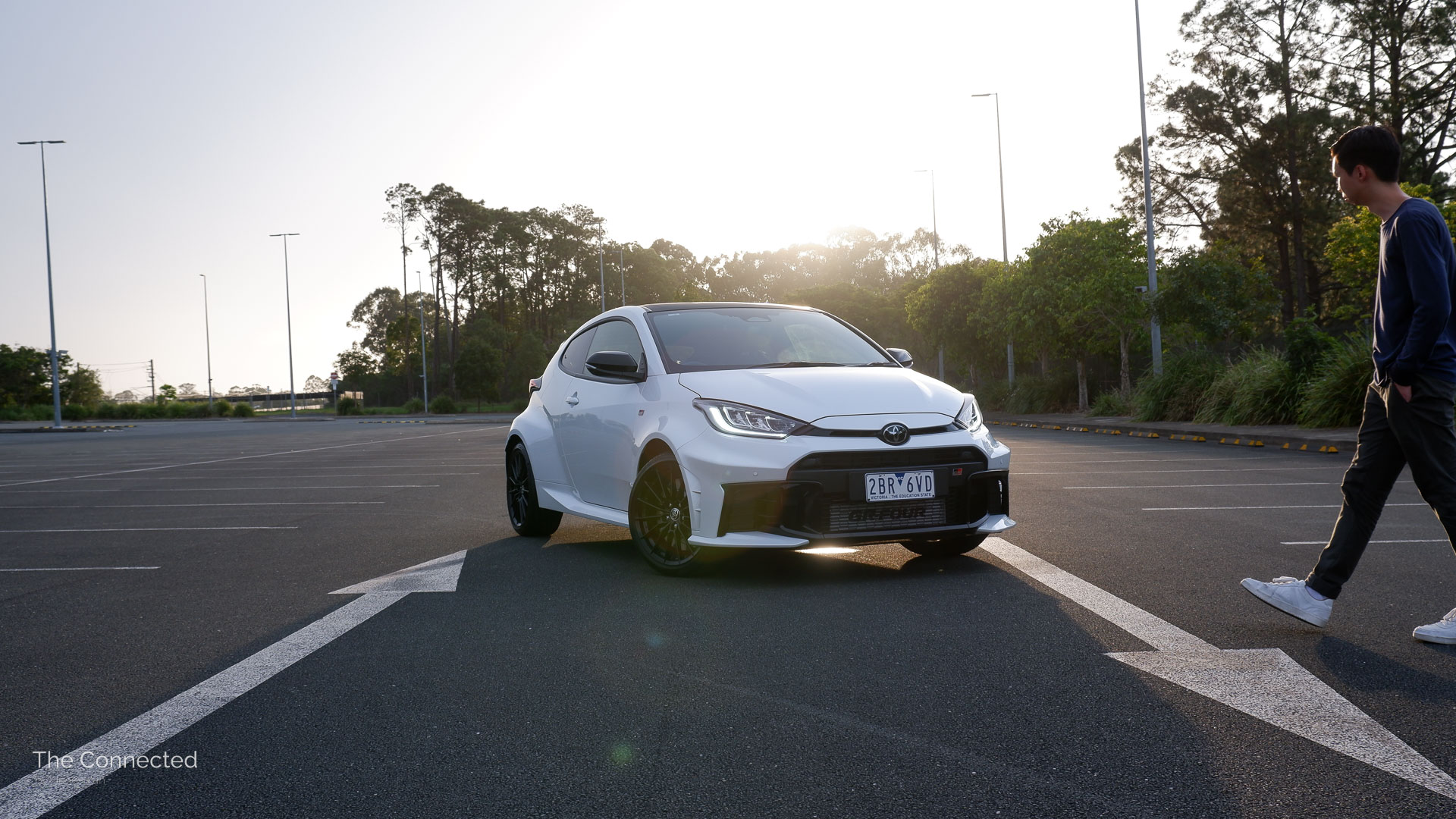 Man walks past the 2026 Toyota GR Yaris GT at a car park during the sunset