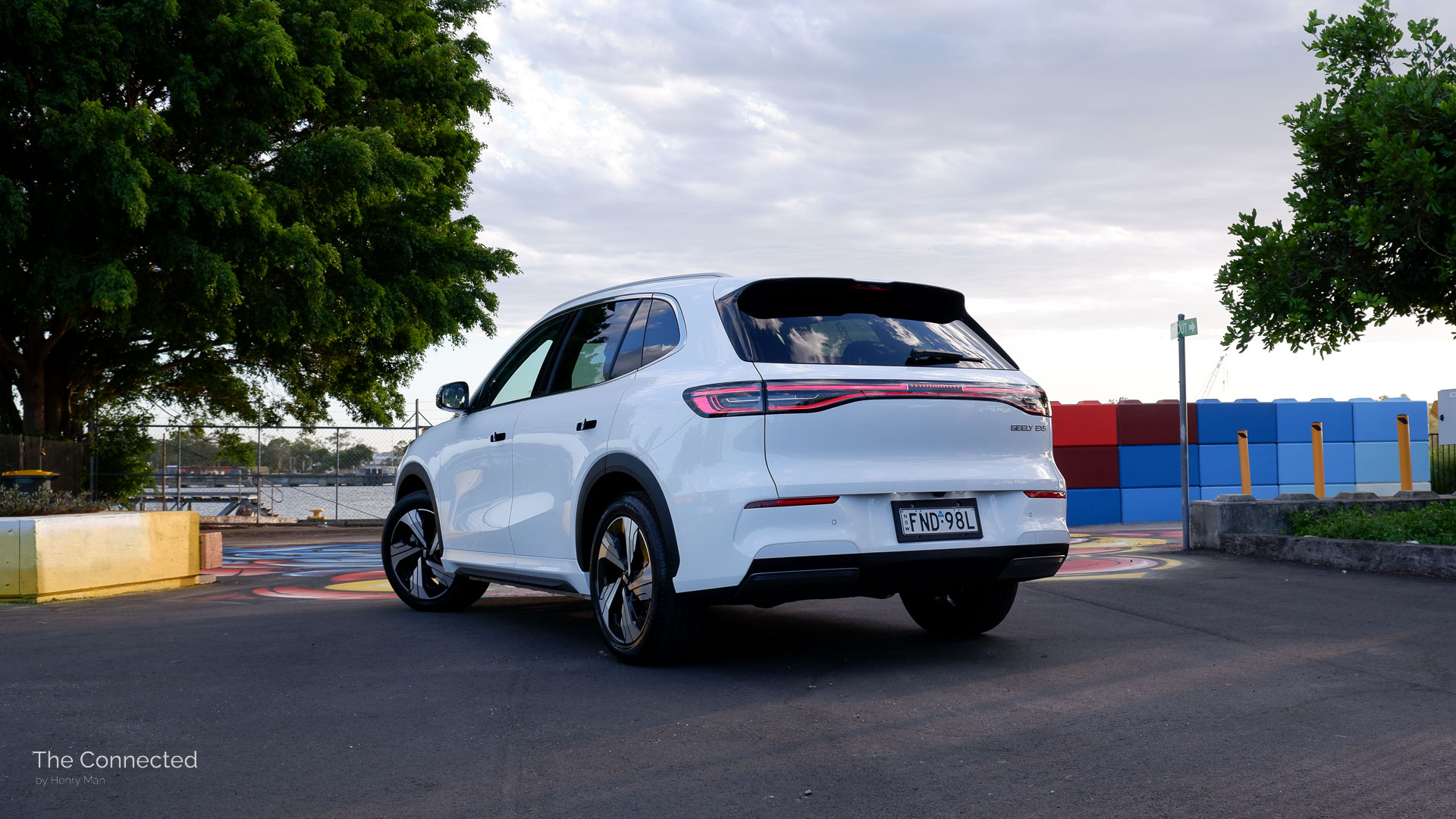 2026 Geely EX5 Inspire rear-quarter view with colourful park and trees behind
