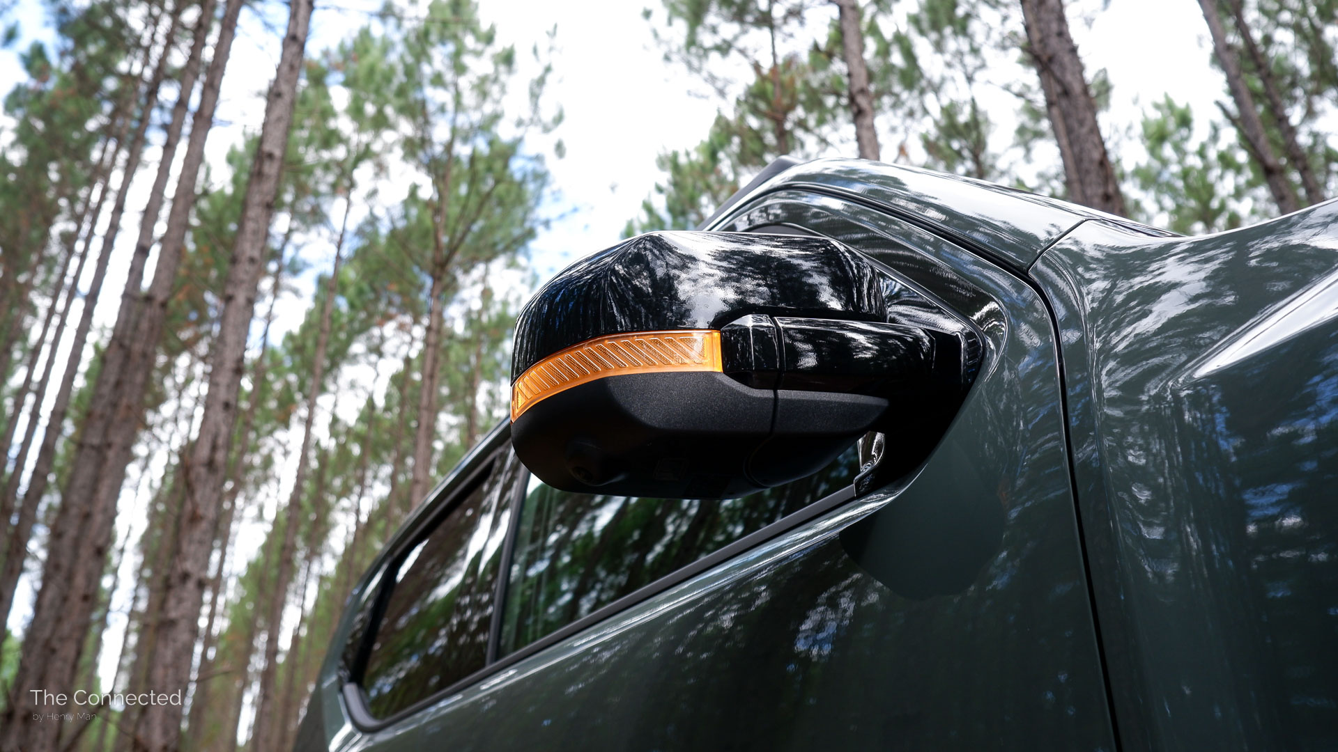 2026 Kia Tasman X-Pro wing mirror with indicator illuminating and forest behind