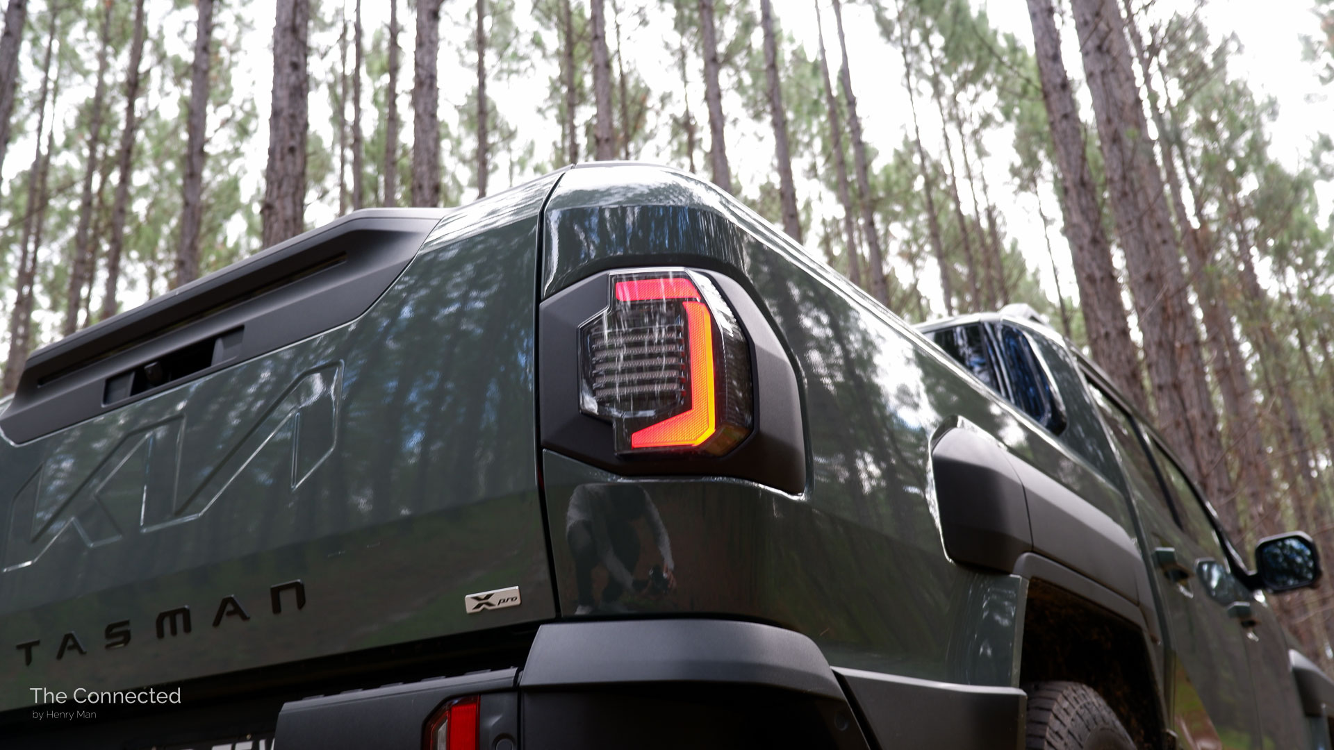2026 Kia Tasman X-Pro rear tail-light with forest behind