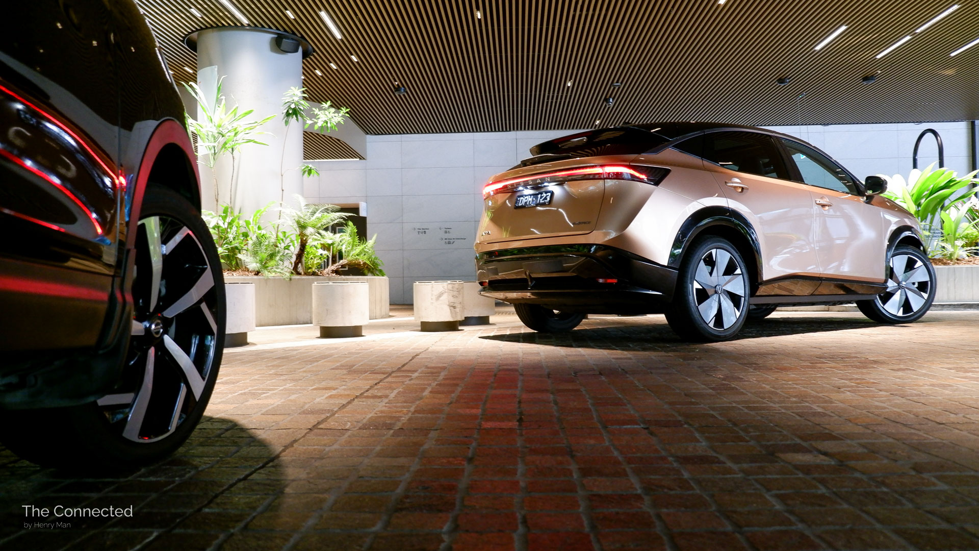 2026 Nissan Ariya Evolve e-4orce rear-quarter view behind Qashqai wheels