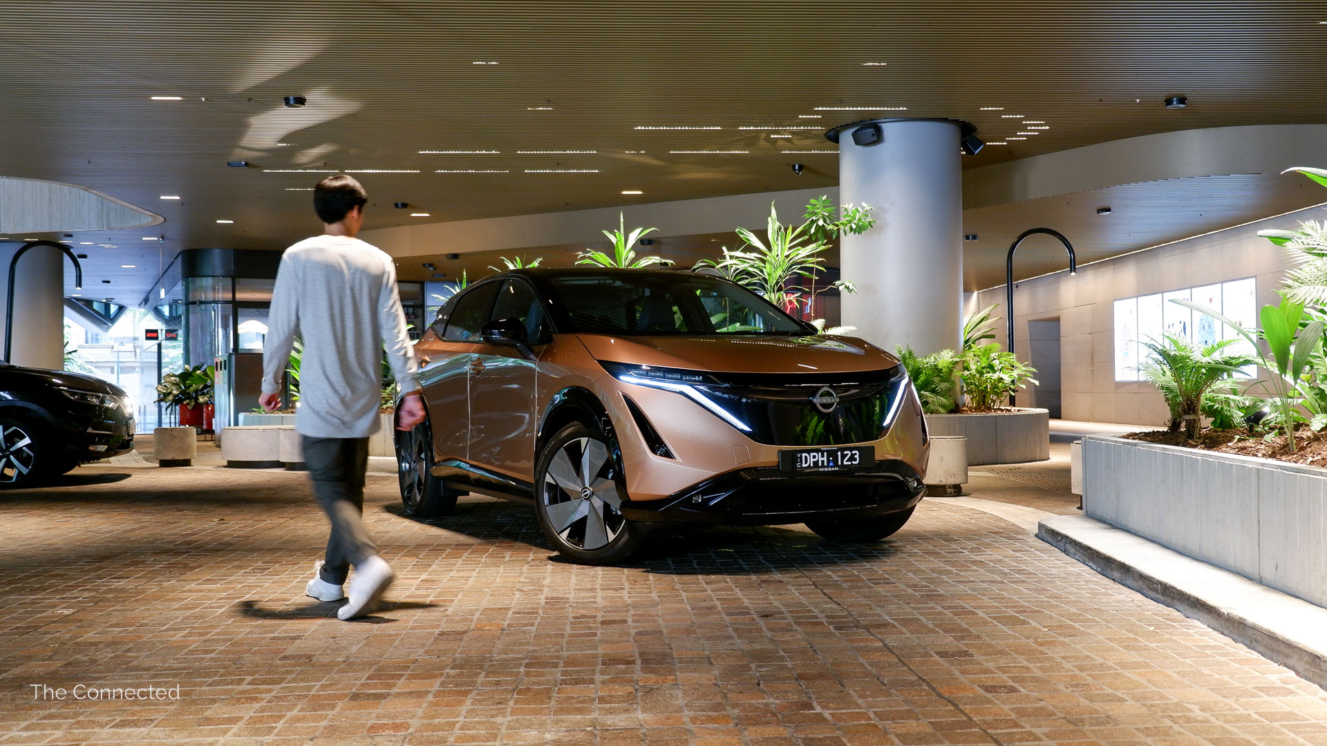 Man walks past the 2026 Nissan Ariya Evolve e-4orce