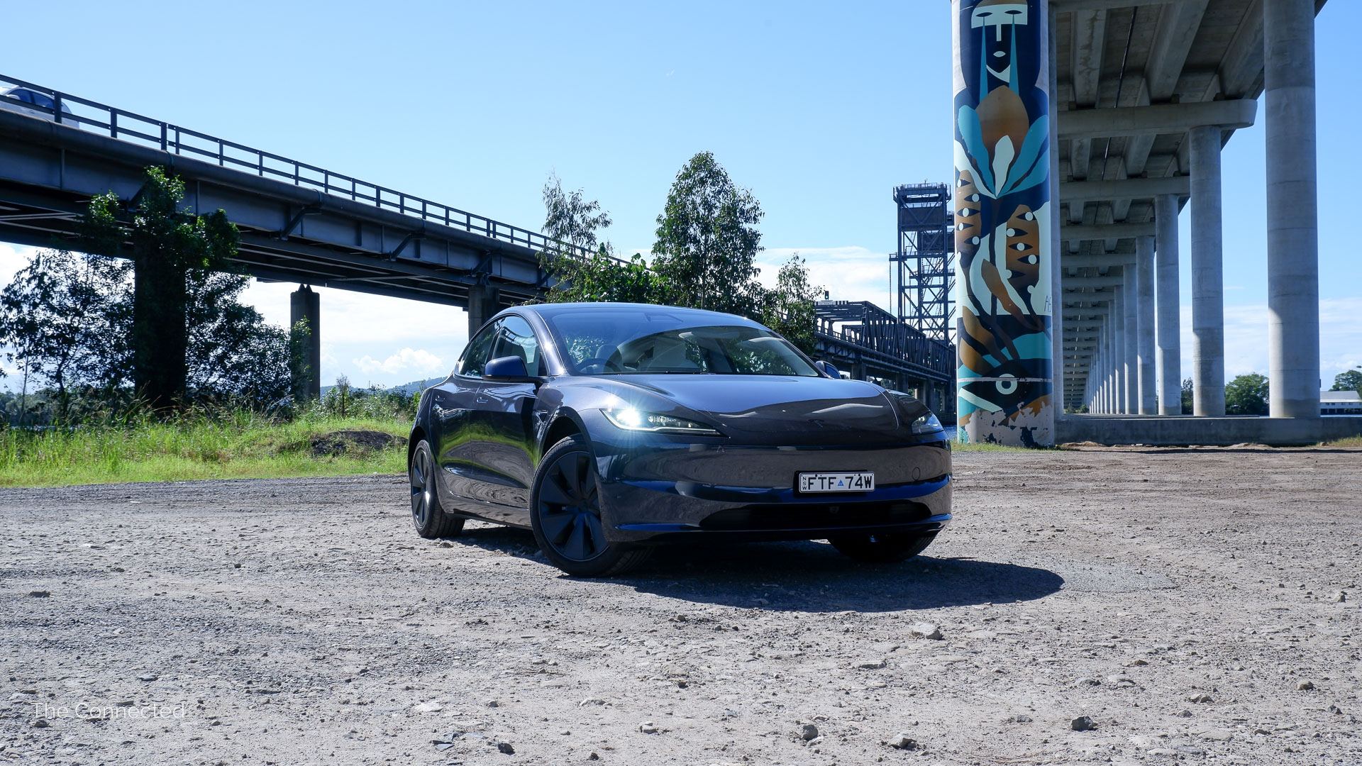 2026 Tesla Model 3 Premium Long Range RWD in front of Harwood Bridge and Clarence River