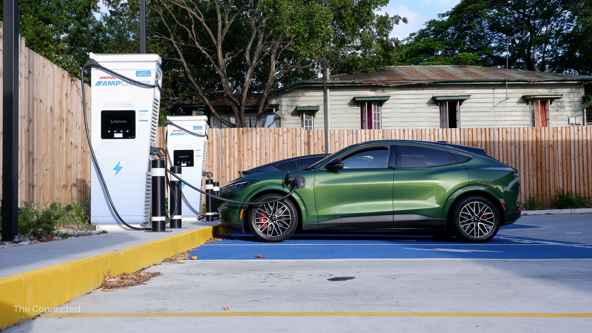2026 Ford Mustang Mach-E Premium charging at AmpCharge fast charging station side view