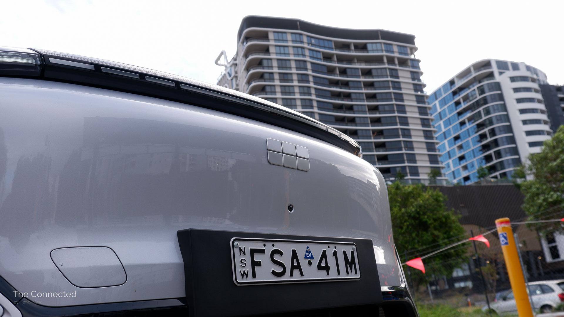 2026 Geely Starray EM-i Inspire front logo with high-rise residential apartments behind