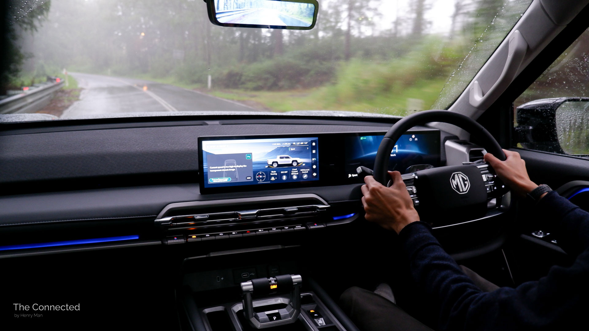 Man driving the 2026 MG U9 Explore Pro through a rainy forest