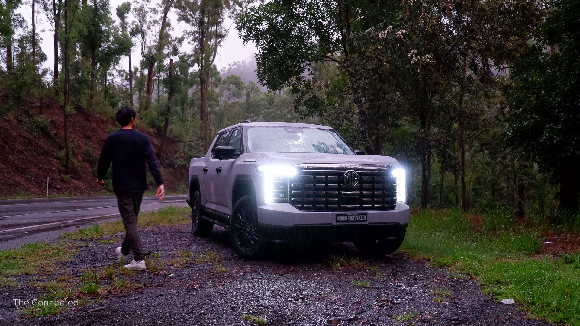 Man walks past the 2026 MG U9 Explore Pro in the forest