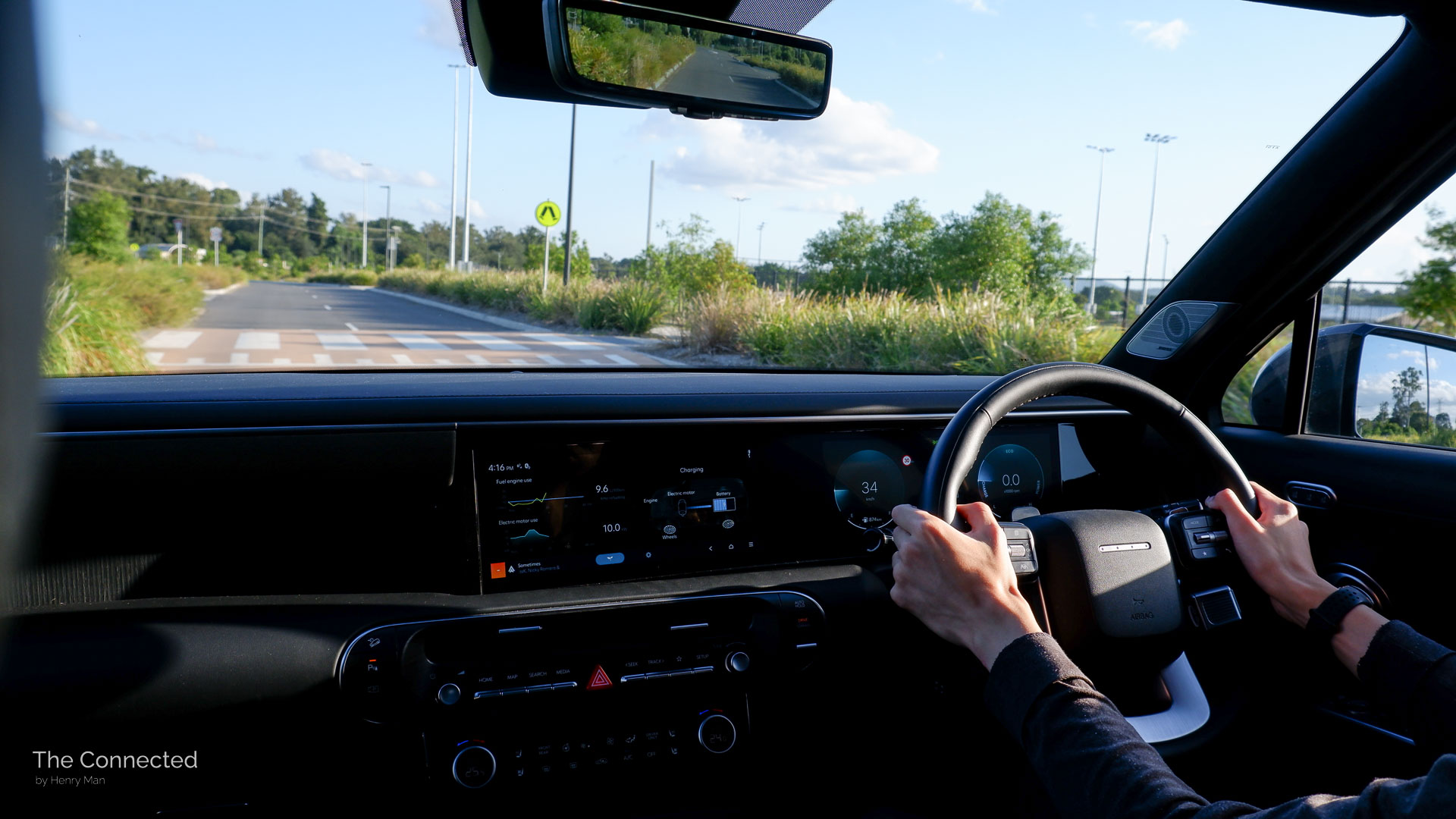 Man driving the 2026 Hyundai Palisade Calligraphy Hybrid through a park and pedestrian crossing