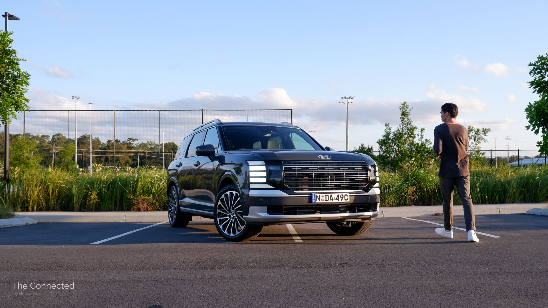 Man walks towards the 2026 Hyundai Palisade Calligraphy Hybrid at a park