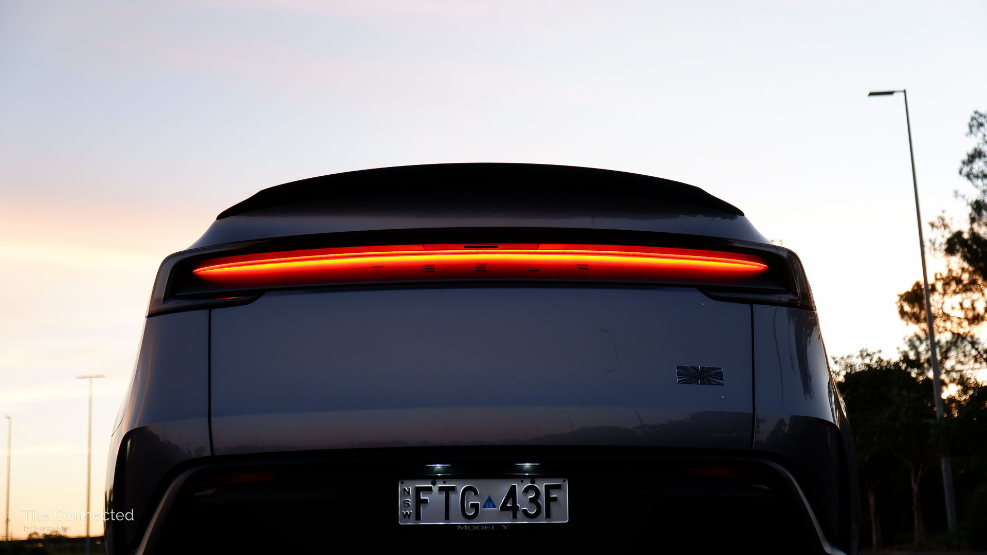 2026 Tesla Model Y Performance AWD rear reflective tail-light bar in the sunset
