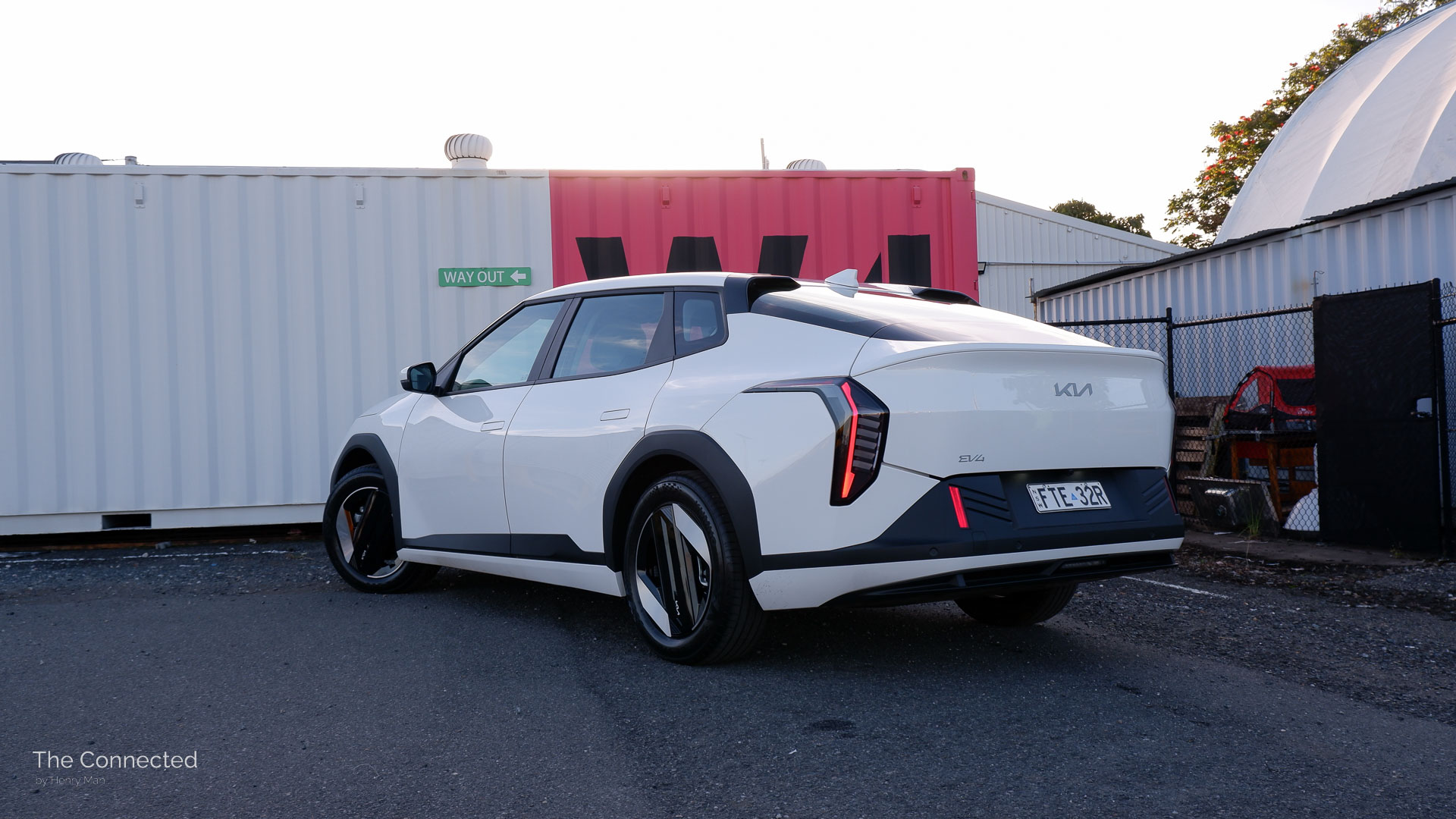 2026 Kia EV4 Air rear-quarter view in front of white shipping container