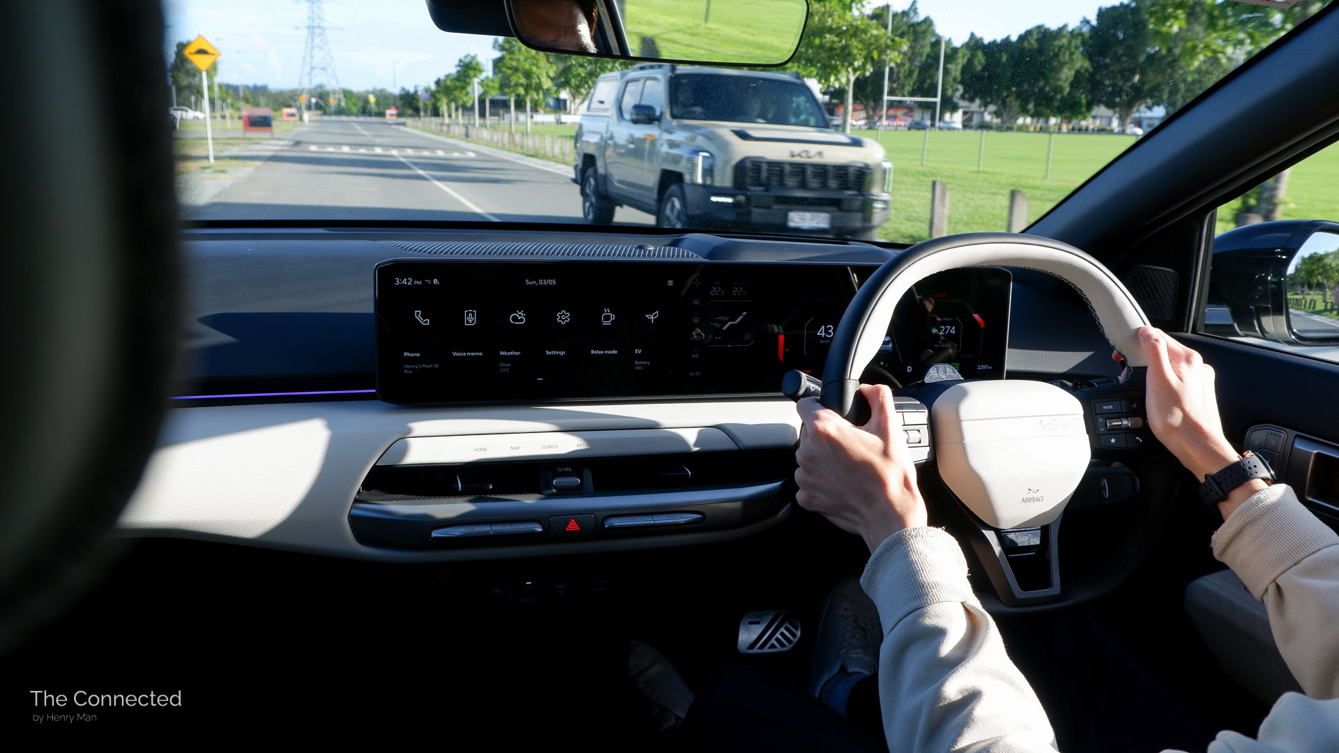 Man driving the 2026 Kia EV4 GT-Line facing a Kia Tasman passing in the opposite direction